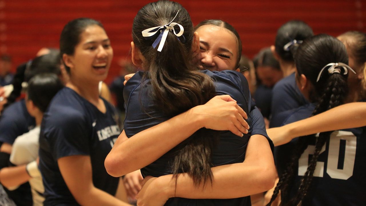 Kamehameha middle Alohalani Chun, center right, hugged teammate Megan Chun after the Warriors clinched the HHSAA Division I girls volleyball championship against Iolani at BYU-Hawaii's Cannon Activities Center on Saturday night.