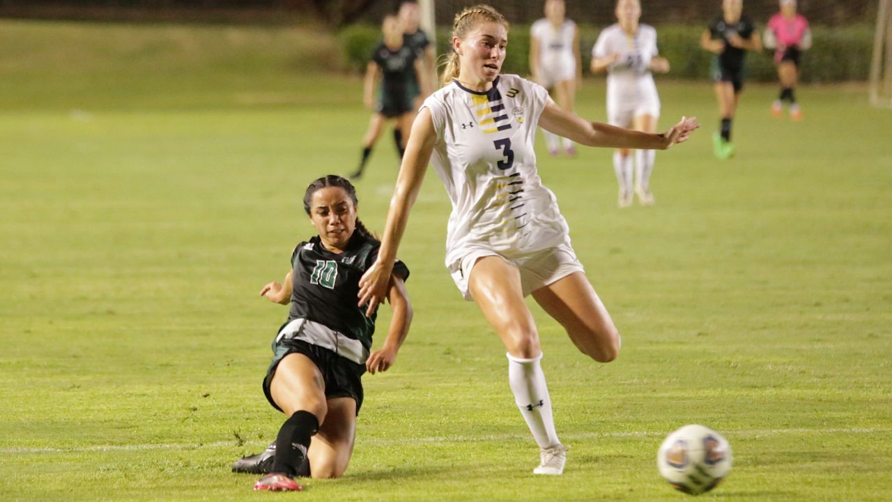 Hawaii forward Amber Gilbert, left, slid into a kick to put the go-ahead goal past UC San Diego forward Kennedy Carter.