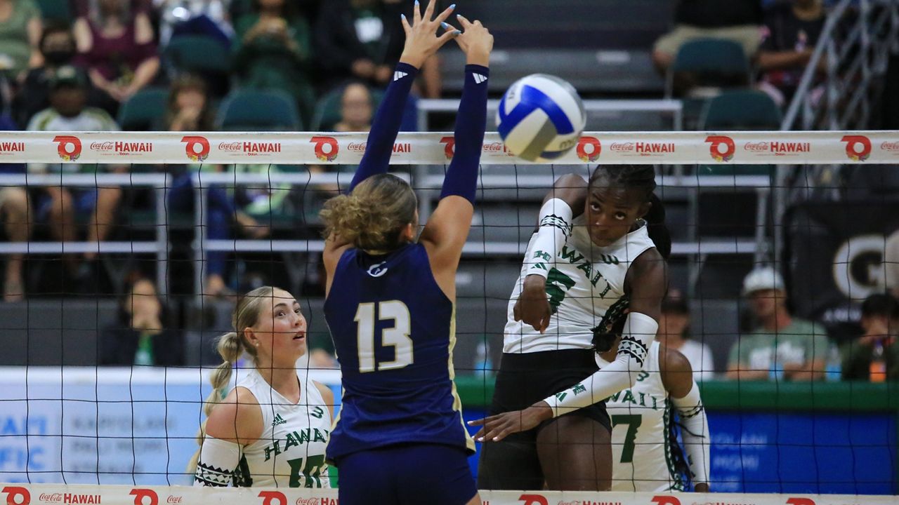 Hawaii middle Jacyn Bamis put down a kill past UC Davis middle Ally Chandler in the teams' meeting at the Stan Sheriff Center on Oct. 11.