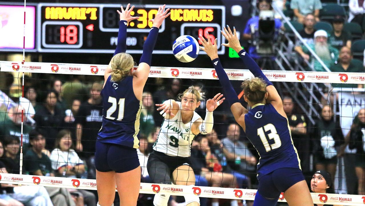 Hawaii hitter Tali Hakas tried to hit through UC Davis' Reese Diersbock (21) and Ally Chandler (13) at the Stan Sheriff Center on Friday night.