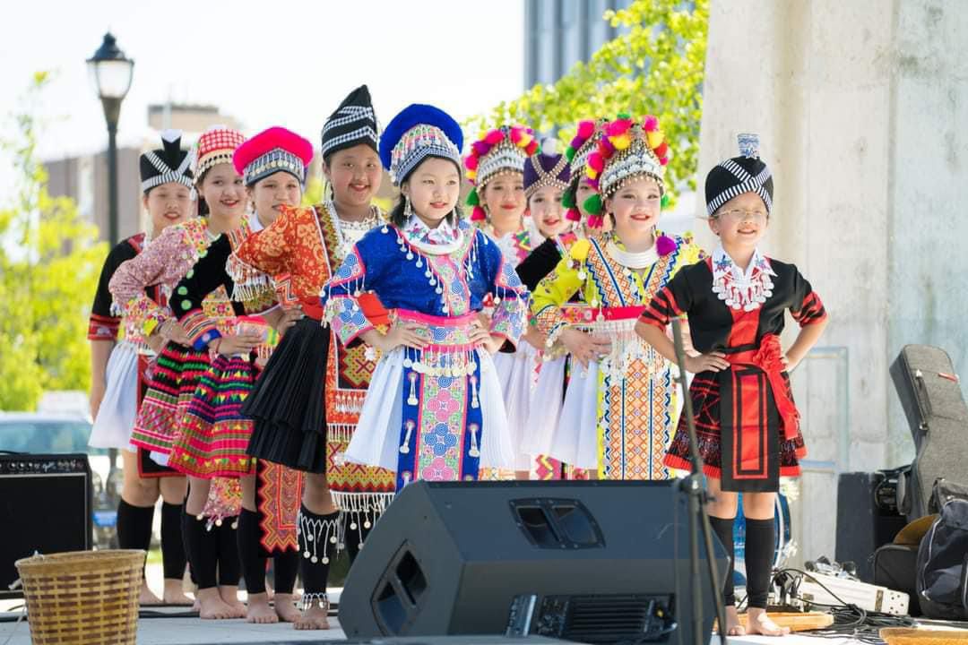 girls on stage preforming in traditional Hmong attire)