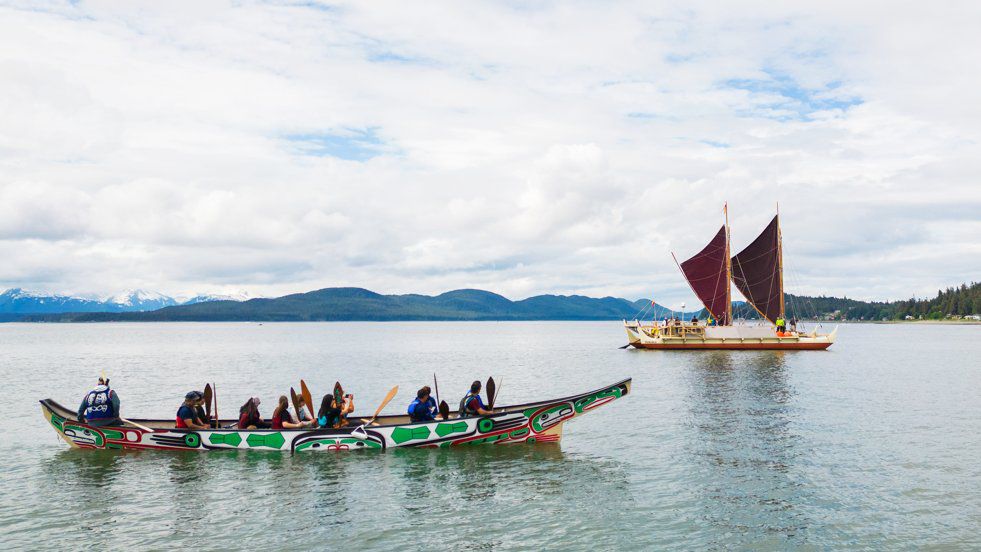 Alaska hosts sent traditional canoes, called yaakws, to escort Hokulea to her mooring at Auke Bay upon completion of the Heritage Sail. (Photo by Polynesian Voyaging Society)