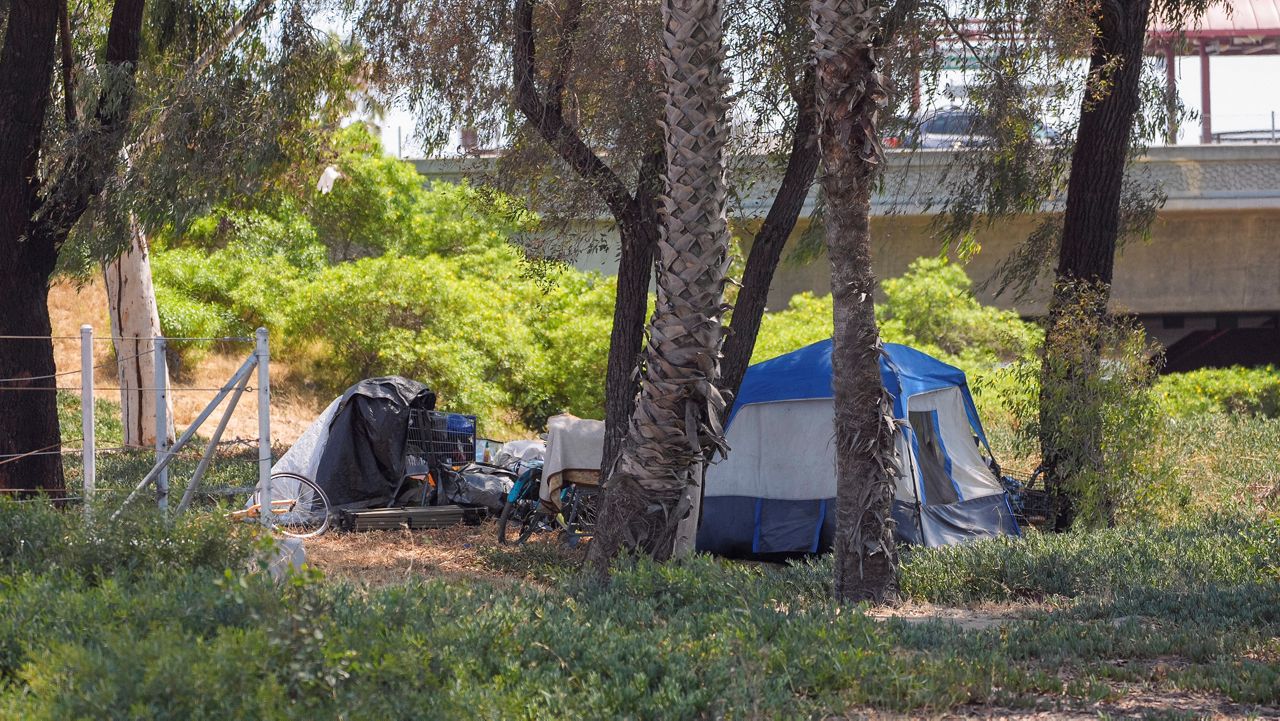 A homeless encampment sits set up next to an off-ramp to the CA-105 freeway Friday, July 26, 2024, in Los Angeles. (AP Photo/Damian Dovarganes)