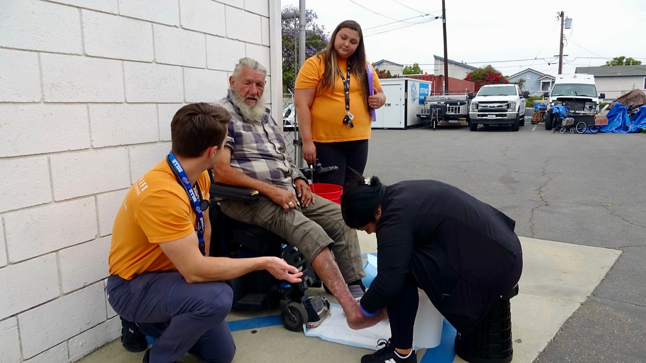 The Cal Optima Health Street Medicine team helps treat Robert Montgomery in Costa Mesa. (Spectrum News/Jo Kwon)