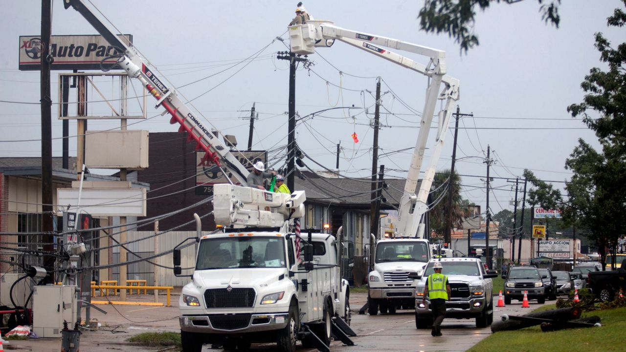 Utility crews work to restore electricity in Houston, Thursday, July 11, 2024. Officials say about 500,000 customers still won't have electricity into next week as wide outages from Hurricane Beryl persist. (AP Photo/Lekan Oyekanmi)