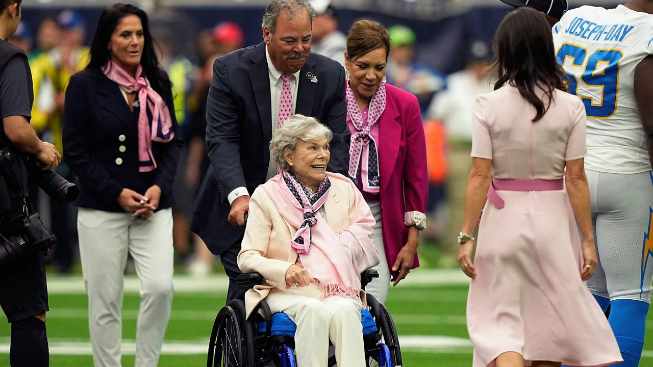 Houston Texans owner Janice McNair, enters with her son, Chairman and CEO Cal McNair before an NFL football game against the Los Angeles Chargers, Sunday, Oct. 2, 2022, in Houston. (AP Photo/David J. Phillip, File)