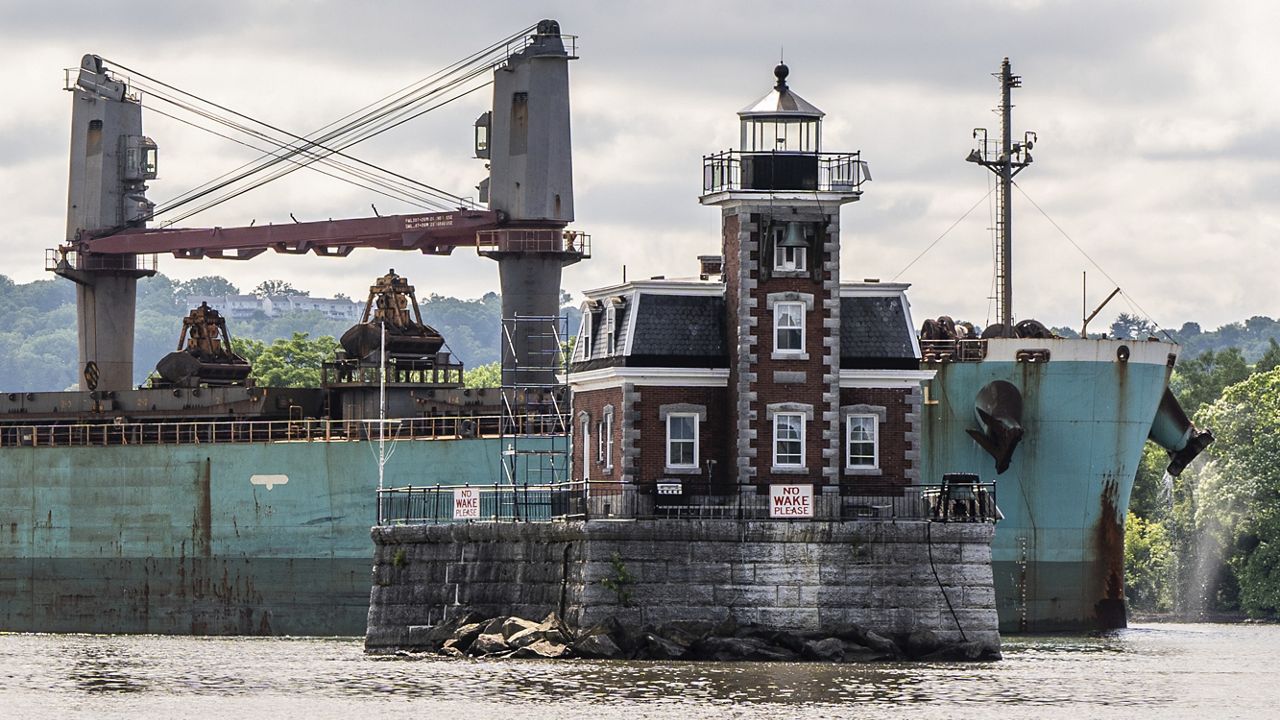 A ship passes the Hudson Athens Lighthouse, Wednesday, June 12, 2024, in Hudson, N.Y. The 150-year-old lighthouse is in danger of toppling into the water, and advocates for the lighthouse in the middle of Hudson River are urgently trying to save it. (AP Photo/Julia Nikhinson)