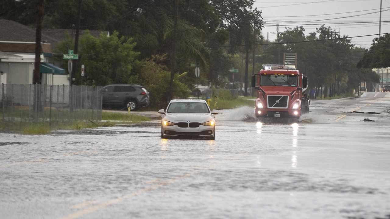 A vehicle is disabled in the flood water along S. 22nd street, Monday morning, Aug. 5, 2024 in Tampa, Fla., as Hurricane Debby passes the Tampa Bay area offshore. (Luis Santana/Tampa Bay Times via AP)