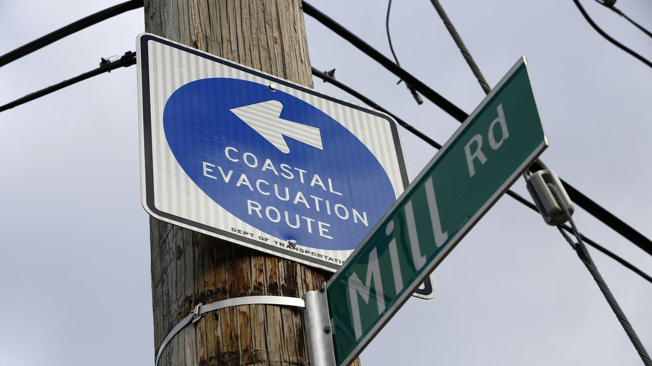 In this Tuesday, Oct. 25, 2016 photo, a sign along Mill Road in the Oakwood Beach neighborhood of Staten Island directs residents away from the coast during an evacuation. (AP Photo/Kathy Willens)