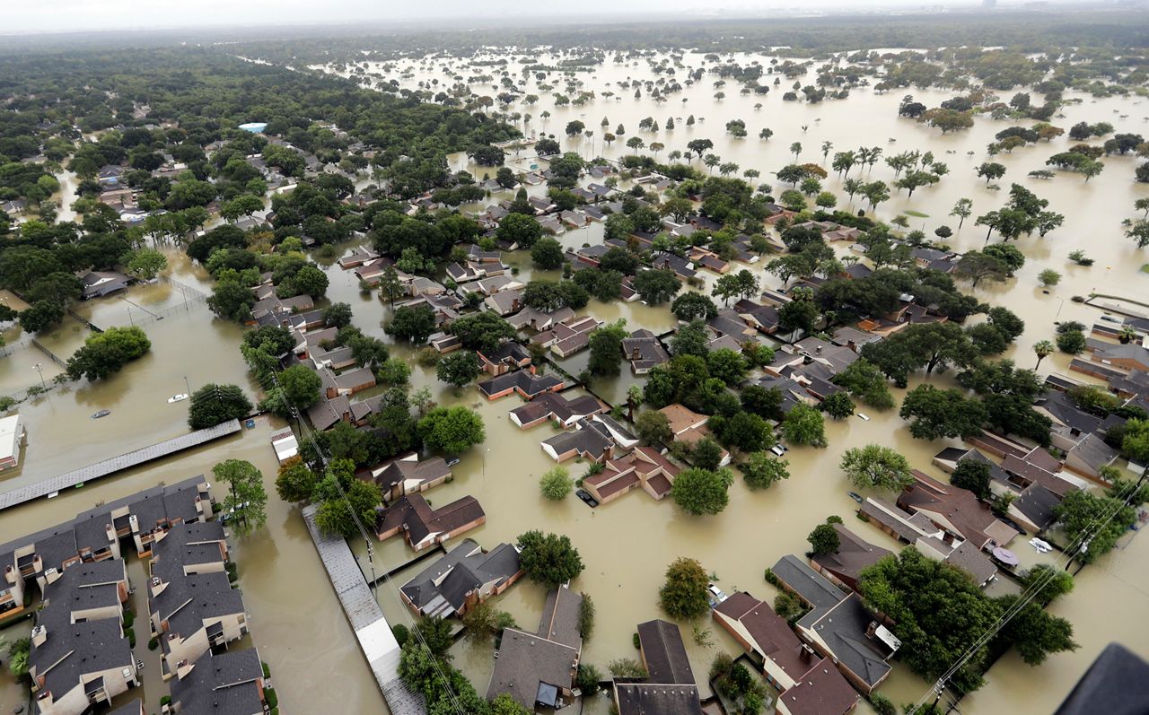 In this Tuesday, Aug. 29, 2017, photo, water from Addicks Reservoir flows into neighborhoods as floodwaters from Tropical Storm Harvey rise in Houston.