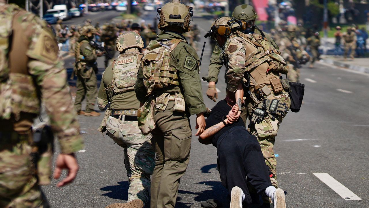 Police detain a man during a protest in the Paramount section of Los Angeles, Saturday, June 7, 2025, after federal immigration authorities conducted operations. (AP Photo/Eric Thayer)