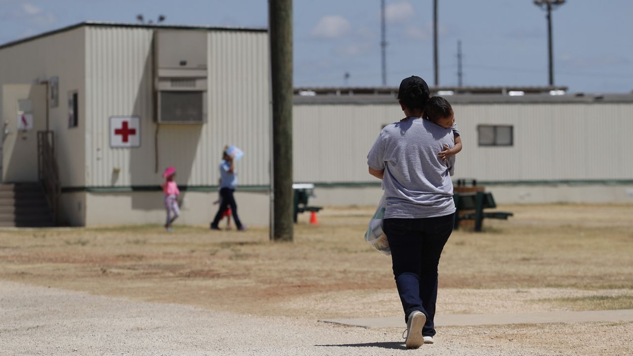 Immigrants seeking asylum walk at the ICE South Texas Family Residential Center, Aug. 23, 2019, in Dilley, Texas. (AP Photo/Eric Gay, File)