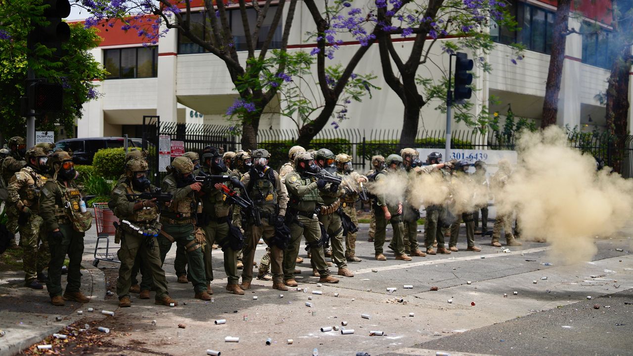Border Patrol personnel deploy tear gas during a demonstration over the dozens detained in an operation by federal immigration authorities a day earlier in Paramount section of Los Angeles Saturday, June 7, 2025. (AP Photo/Eric Thayer)