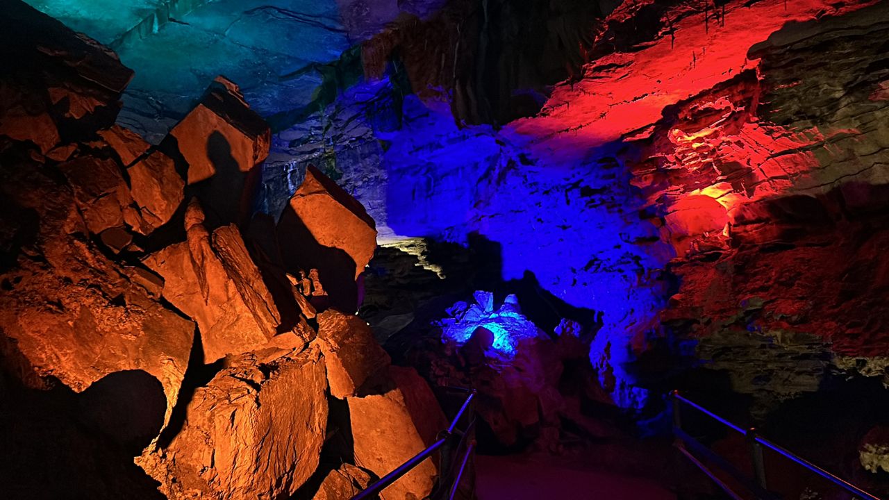 yellow, blue and red lights shining on cave walls