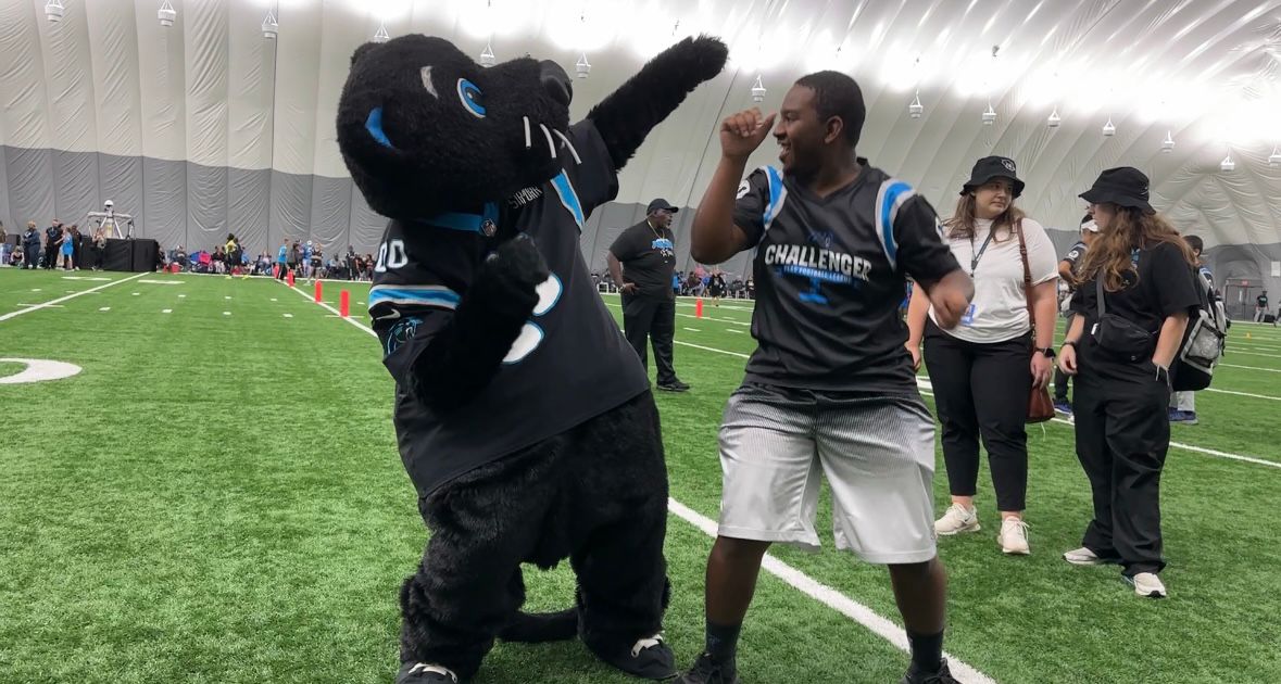 Sir Purr and a member of the Greensboro Panthers Challenger Flag Football League dance.