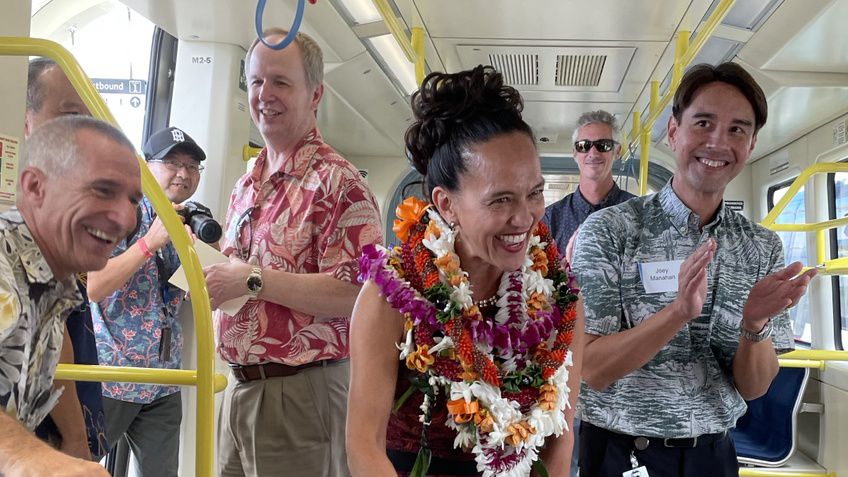 Lori Kahikina, executive director and CEO for HART, receives applause as she boards Skyline for its inaugural ride. (Spectrum News/Lianne Bidal Thompson)