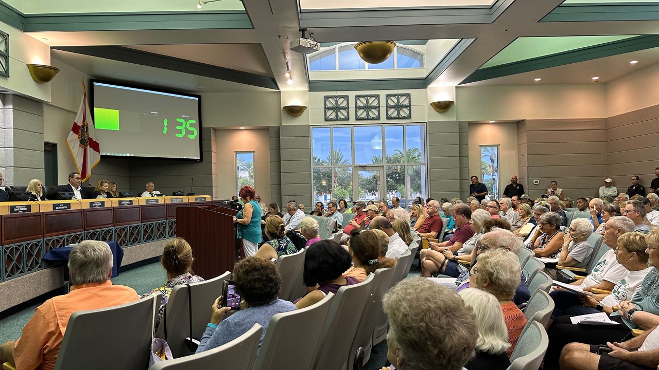 Fran Canfield (at podium) speaks in opposition to a proposed fuel tank terminal at a packed Ormond Beach City Commission meeting Tuesday night. (Spectrum News/Reagan Ryan)