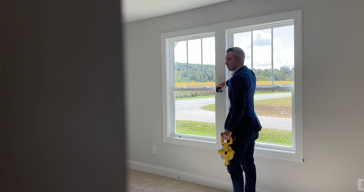 John Walker using a distance laser in a new build home.