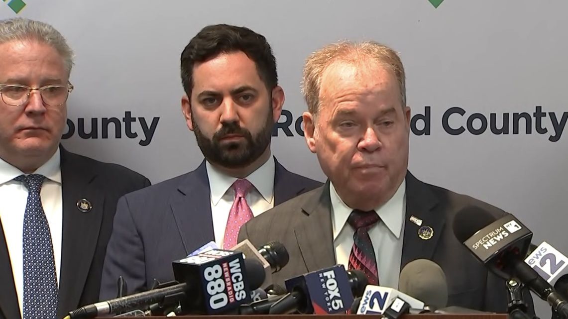 Three persons at a news conference.