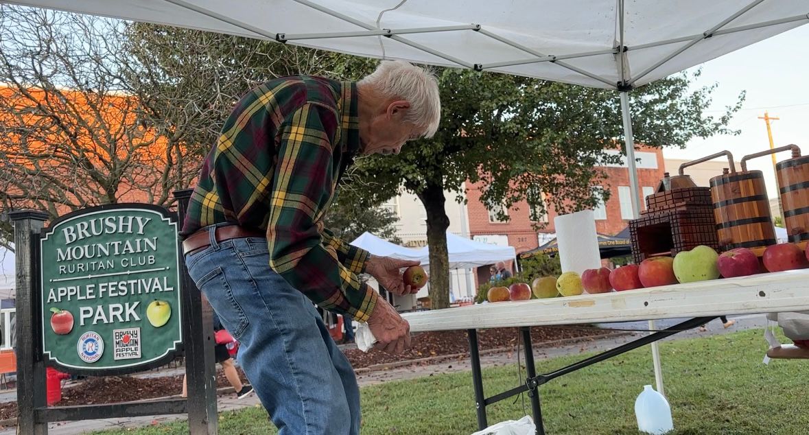 Tom Brown looks at his apples.