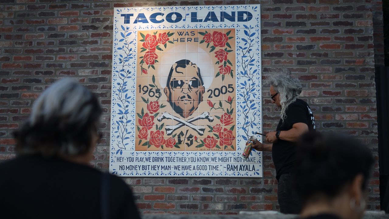 Roland Fuentes lights a candle at Ramiro 