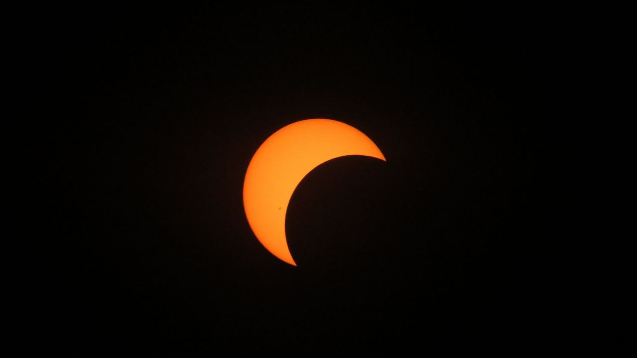 This image shows the start of the annular solar eclipse. When the moon is farthest from Earth and it is between the planet and sun, it appears smaller and does not block the entire view of the sun. The sun creates a ring around the moon, calling it a ring of fire. (Spectrum News/Anthony Leone)