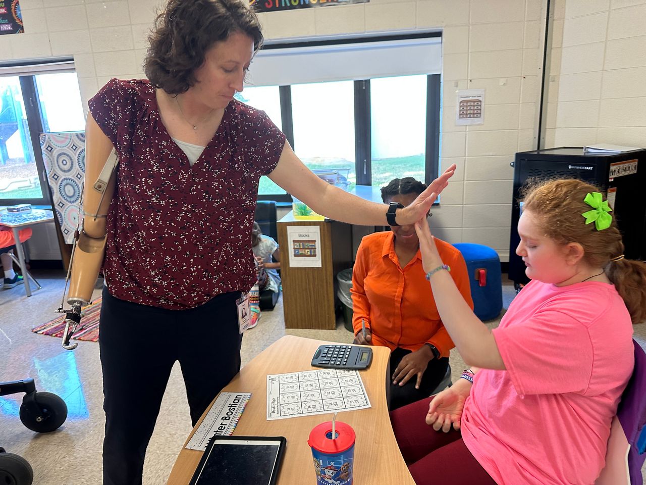 Kelli Brentnell giving a student a high-five for completing an activity.