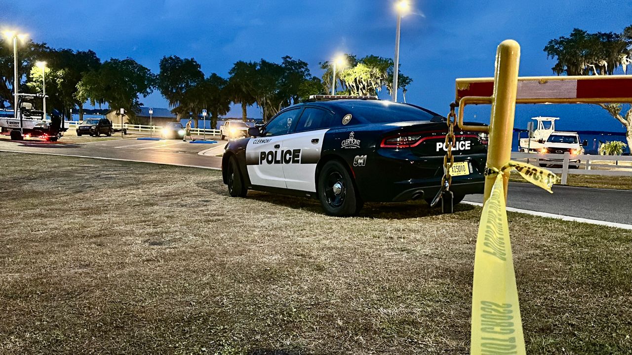 A police vehicle sits near a dock in Clermont where a missing swimmer was found. (Spectrum News/Nick Allen)