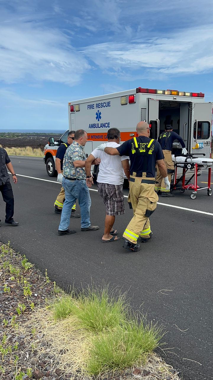 Gov. Josh Green walks the driver to the ambulance. (Photo courtesy the Office of the Governor)