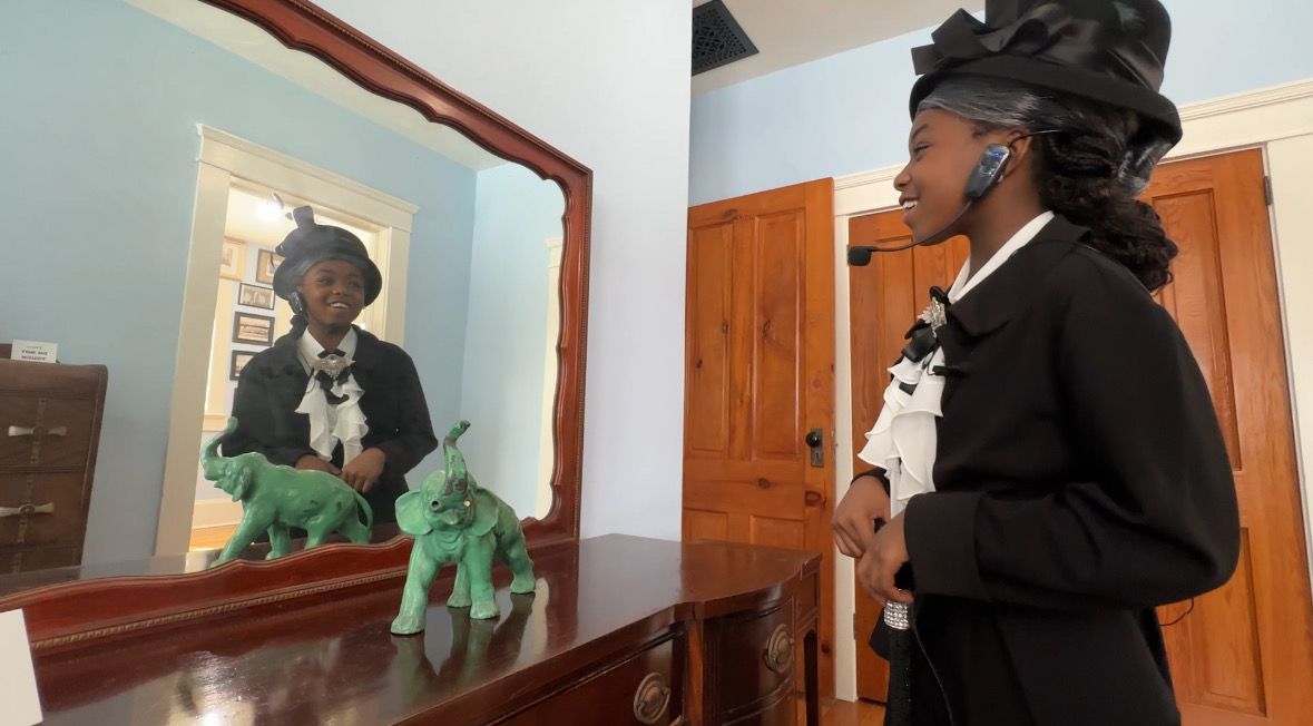 Paisley Henry looks in the mirror and sees Dr. Mary McLeod Bethune. She portrayed her during a celebration of Dr. Bethune’s life July 10. (Spectrum News/Devin Martin)