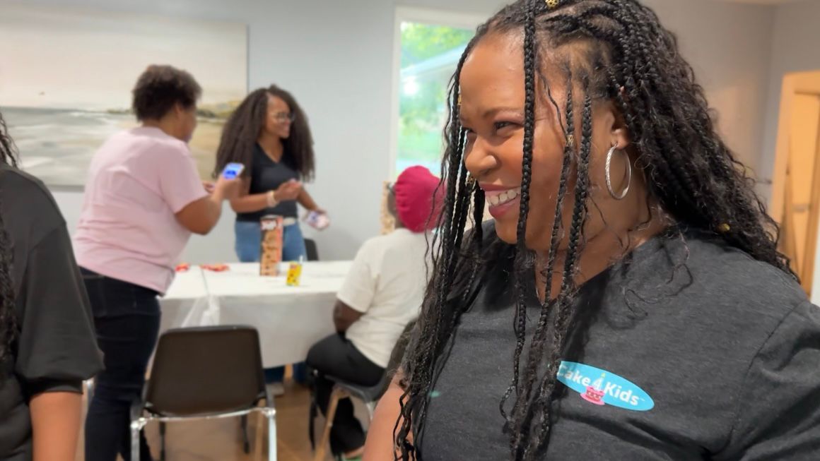 Mashavu Gordon hands out cupcakes at a monthly birthday celebration. (Spectrum News 1/Rachel Boyd)