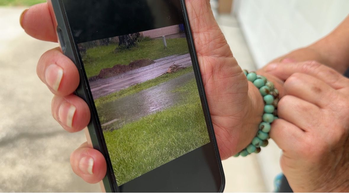 Denise Marie shows pictures of the storms aftermath from July 15. (Spectrum News/Devin Martin)