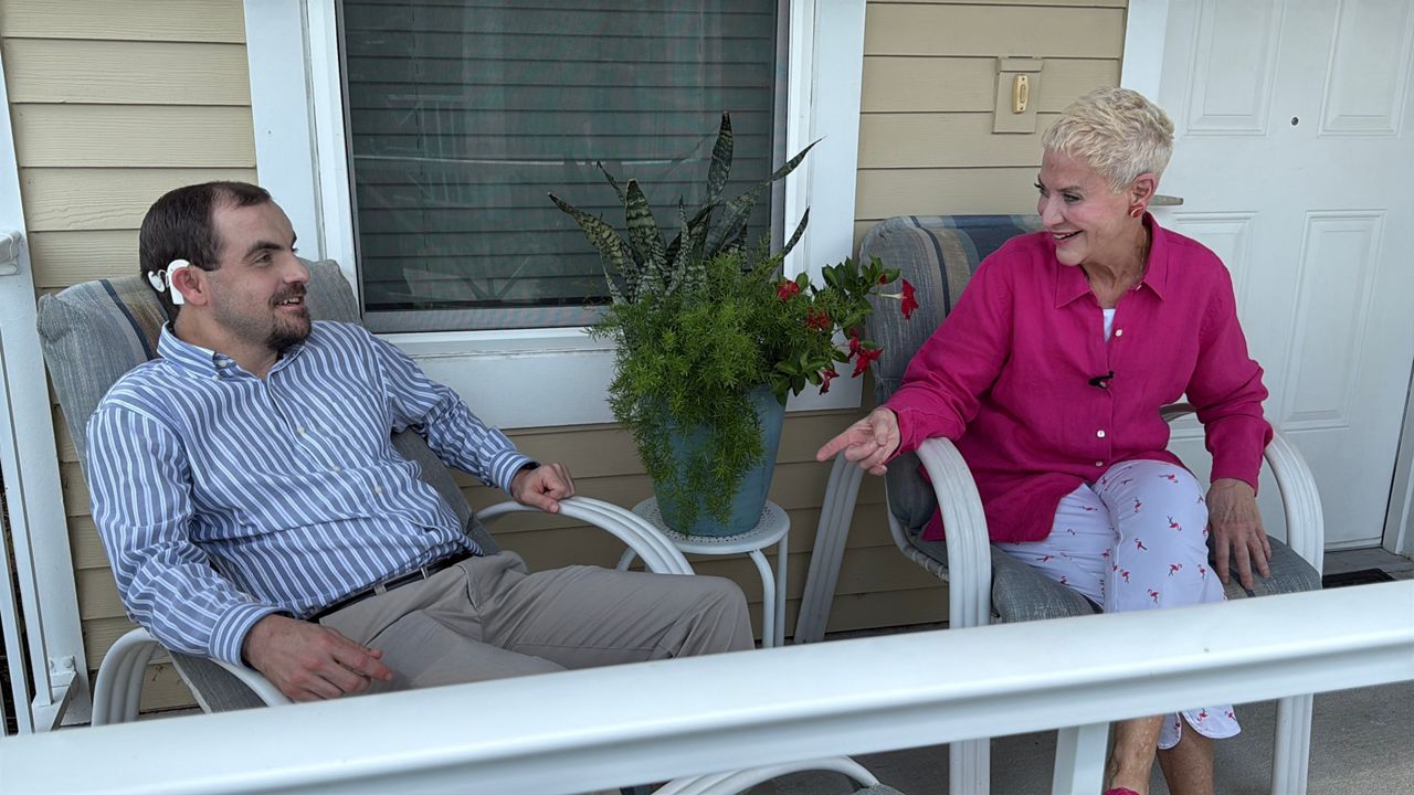 Hart McConnell and his mother Criss chat on his front porch