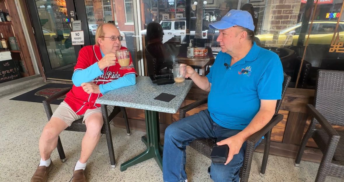 Carrie West (left) and his husband Mark Bias West enjoy a cup of coffee in Ybor City. (Spectrum Bay News 9/Lizbeth Gutierrez)