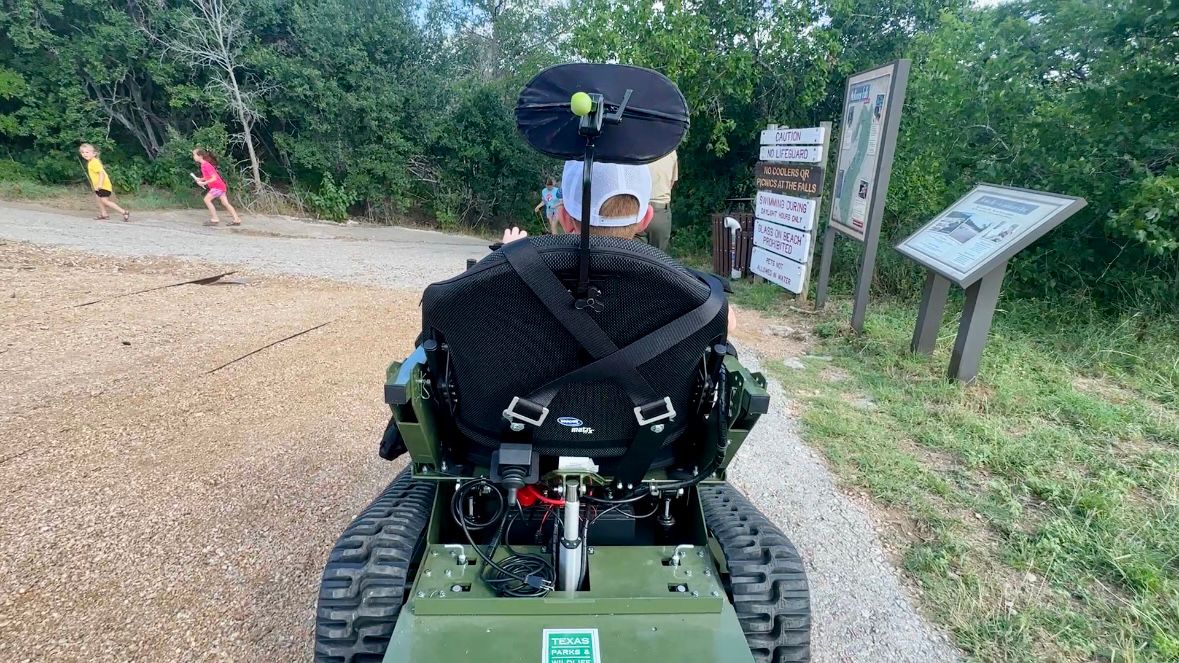 Finley McKeag uses an all-terrain track chair on a trail at McKinney Falls State Park in Austin. (Spectrum News 1/Crystal Dominguez)