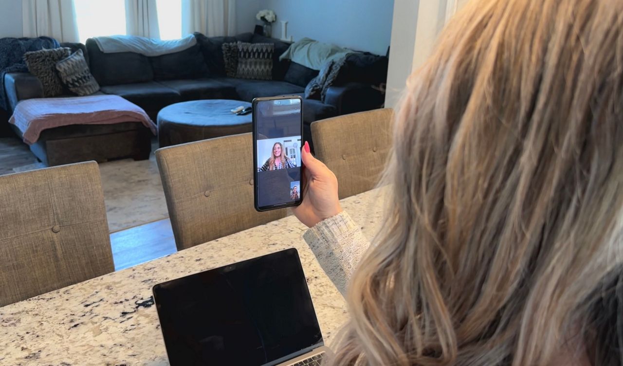 Amber Lawson face timing with a family she carried a baby for.