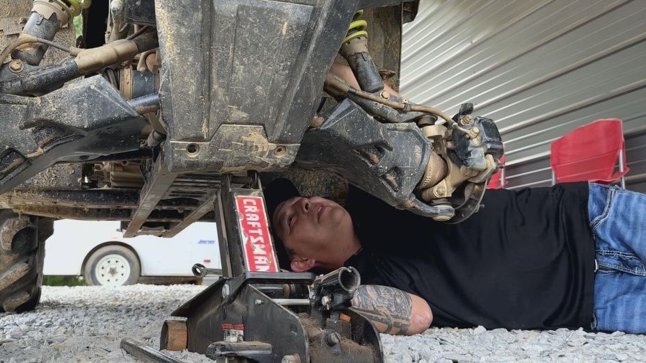 Carl Garcia working on a four-wheeler at his home.