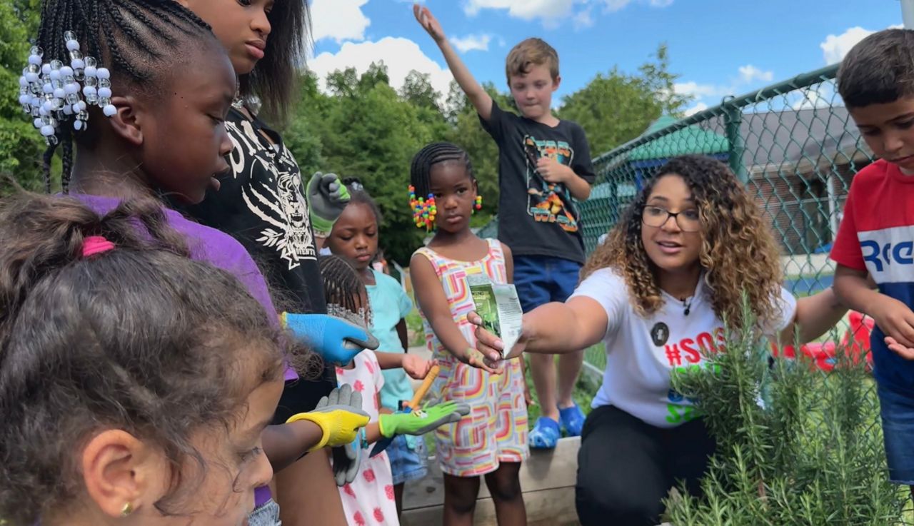 Betsy Rodriguez giving kids seeds for their garden.