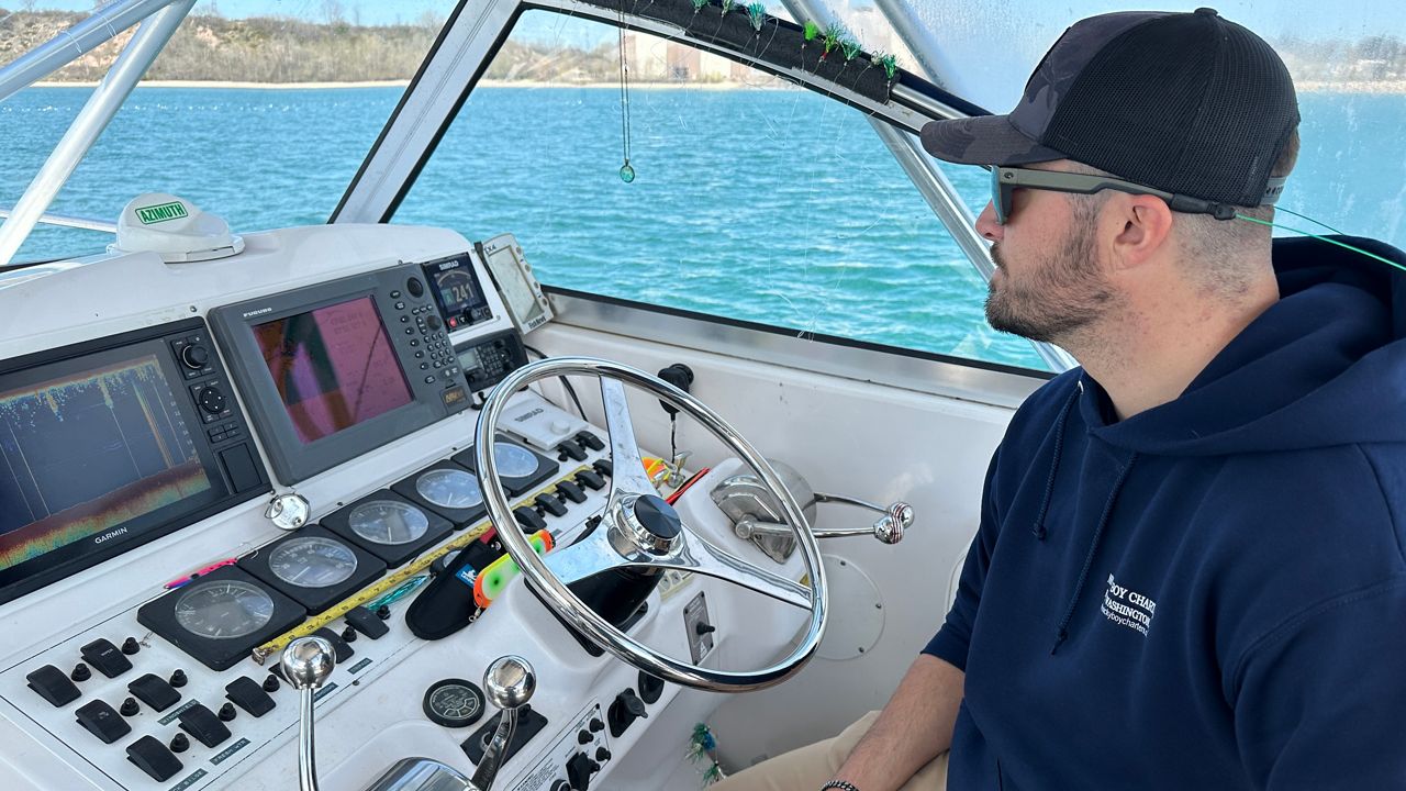 Cody Severinsen sits behind the wheel of the charter boat he operates for Nicky Boy Charters