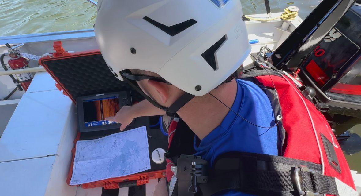 Elijah Childers looking at sonar equipment.
