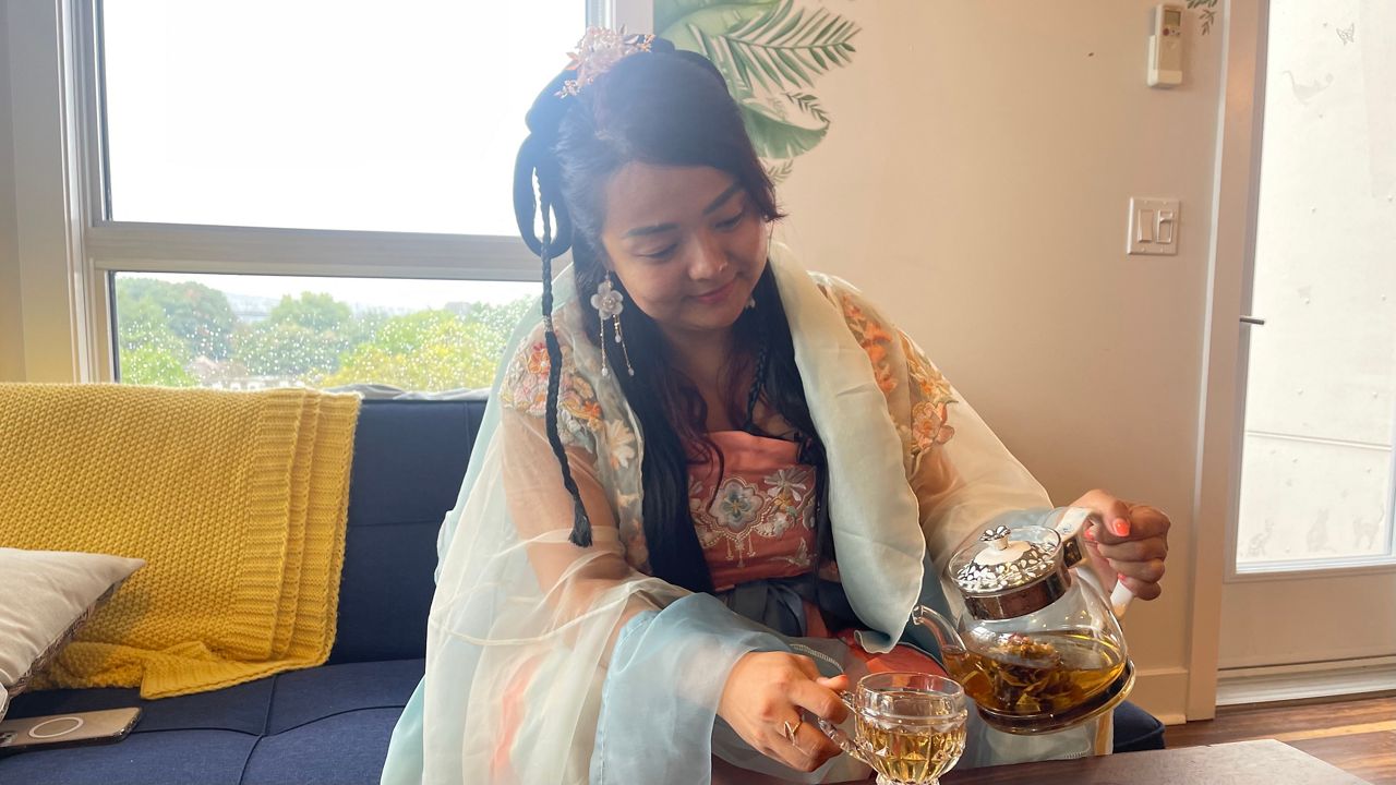 Hexiao Wan pours a beverage. 