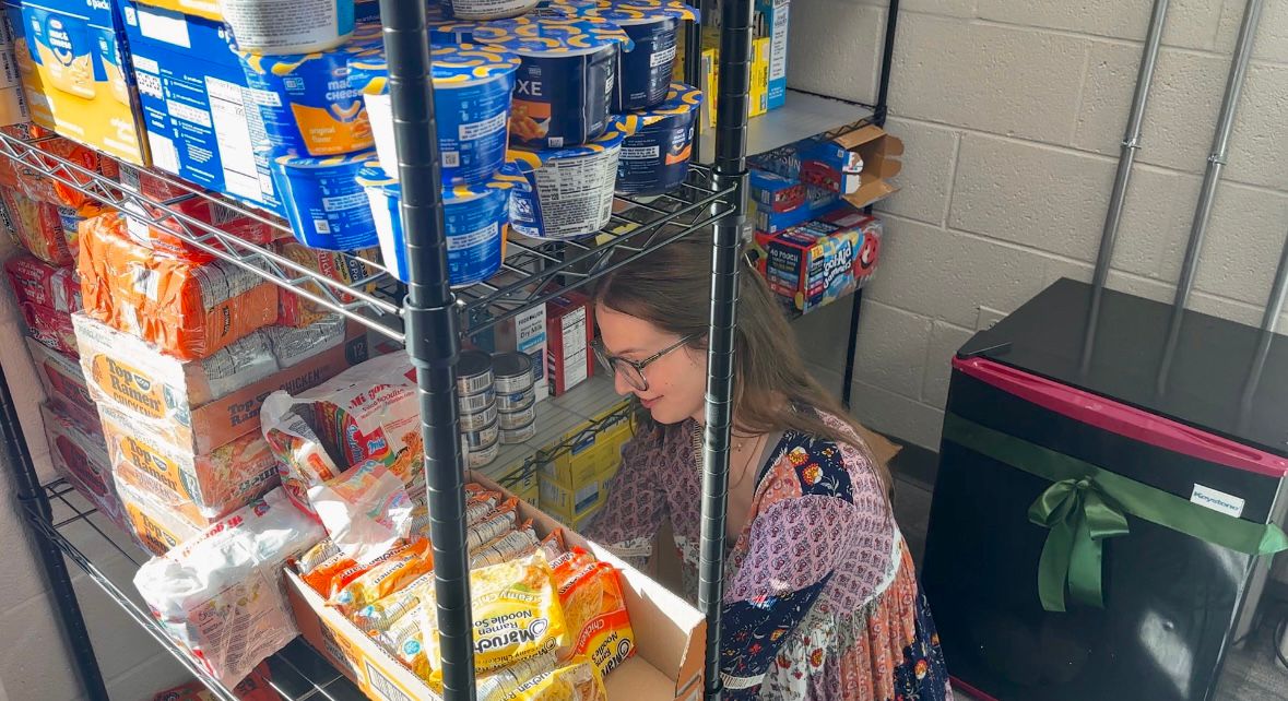 Greensboro student Sloanne Peterson stocks a new food pantry on campus. (Spectrum News 1/Sasha Strong)