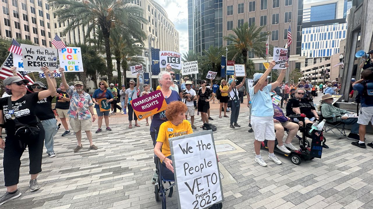 Dozens of people gather outside Orlando City Hall Thursday afternoon for a 