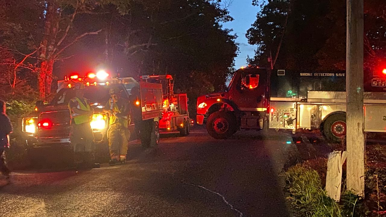 Fire crews from central Maine block the road near the site of a plane crash Tuesday in Litchfield. (Spectrum News/Susan Cover)