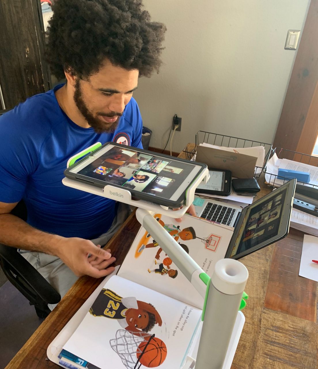 Kylen Granson looks at books and images in this photo from April 2021. (Spectrum News 1/Travis Recek)