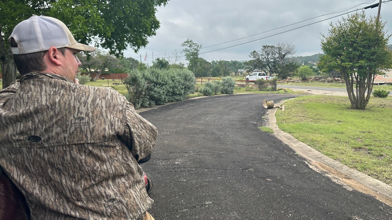 Tucker Nickells watches neighbors clean-up after historic flooding in Kerrville. (Spectrum News 1/Lauren Kendrick)