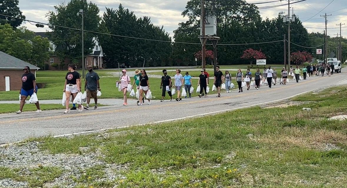 More than 50 food advocates walked two miles carrying groceries to demonstrate what it's like to carry groceries home in the heat. 
