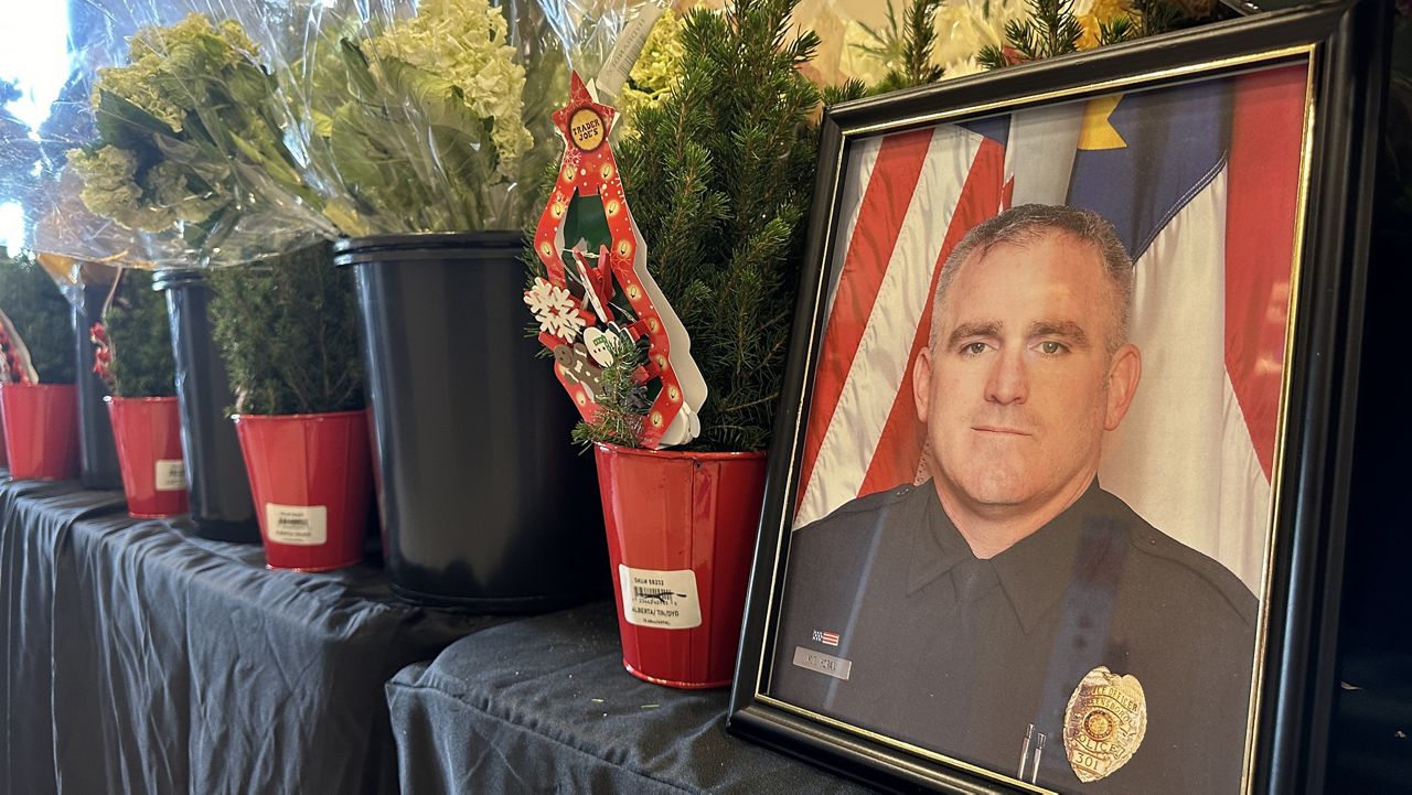 Officer Horan's memorial inside GPD headquarters. Christmas trees and flowers line tables as community members honor the officer. 