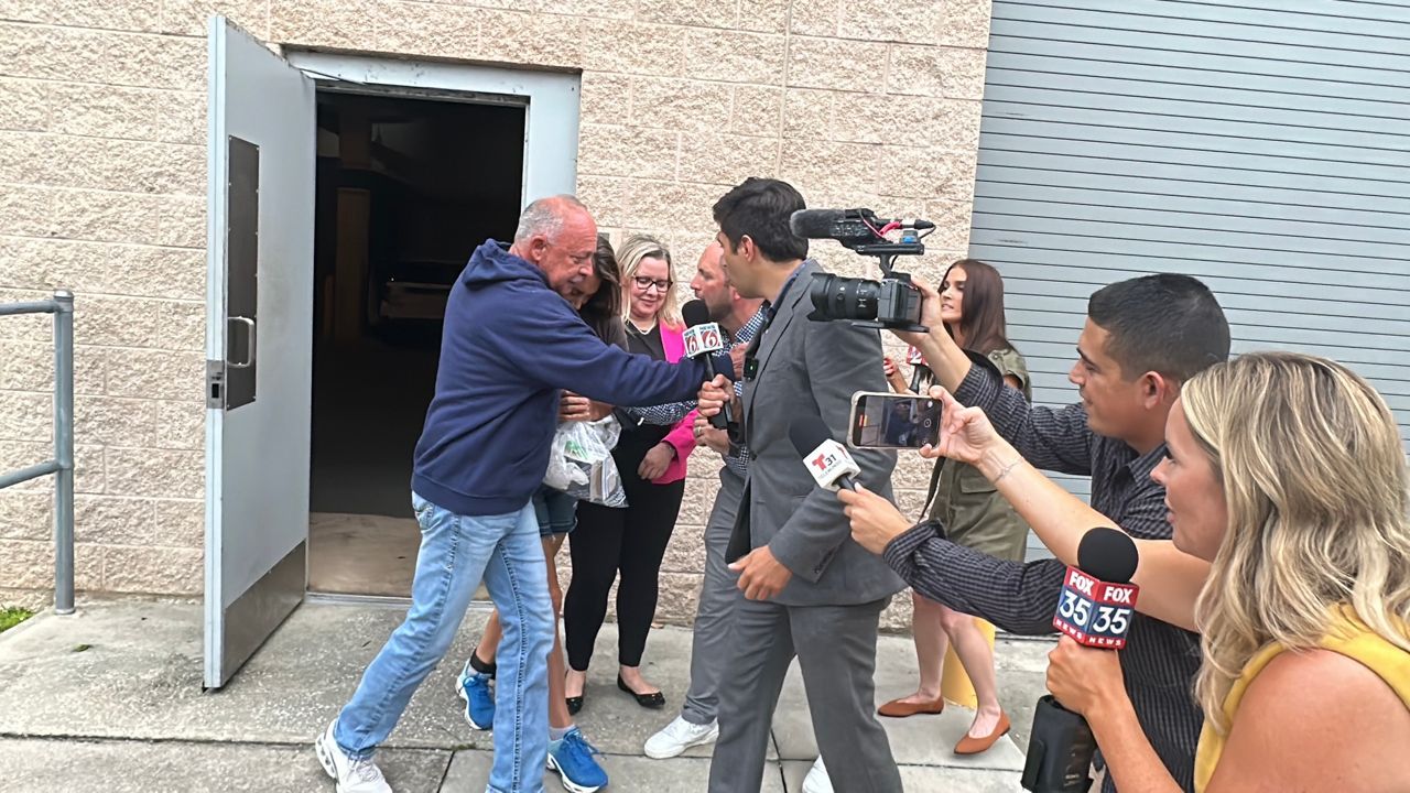 Media surrounds Robin Severance Lopez (located toward the back wearing blue sneakers) as she is released from the Lake County Jail on bond. (Spectrum News/Nick Allen)