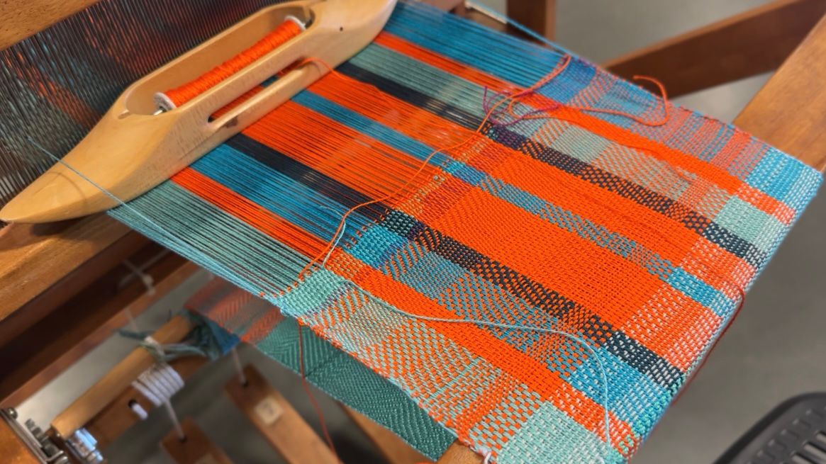 A loom in the process of weaving a pattern is operated at the FiberFest. (Spectrum News 1/Rachel Boyd)